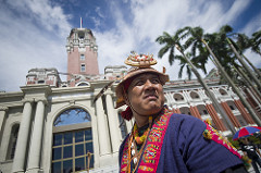 An indigenous representative stands in front of the Presidential Office Building.