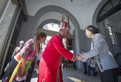 President Tsai shakes hands with an indigenous individual wearing his red traditionalcloth.