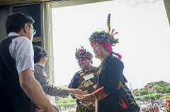 總統與穿著黑色傳統服飾的原住民握手